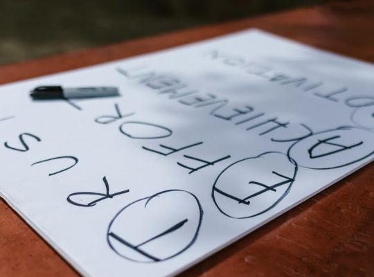A paper with motivational words and markings placed outdoors on a table.